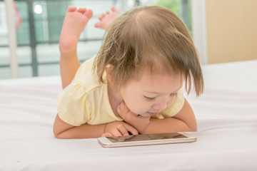 Naklejka premium Baby kid using smartphone. Isolated on white background