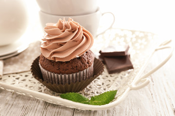Tasty chocolate cupcake on tray