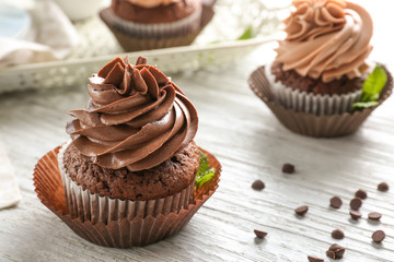Tasty chocolate cupcake on wooden table