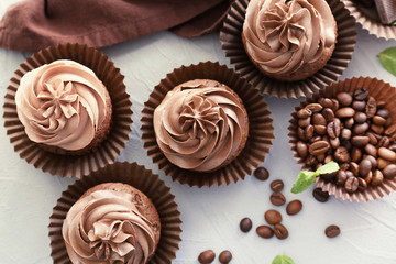 Tasty chocolate cupcakes on textured background