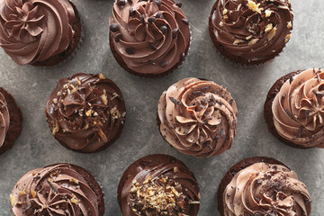Tasty chocolate cupcakes on grey background