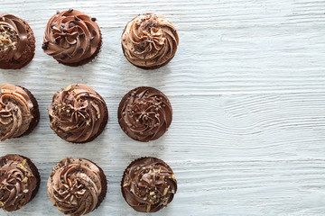 Tasty chocolate cupcakes on wooden background