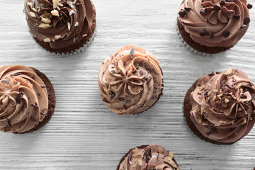 Tasty chocolate cupcakes on wooden background