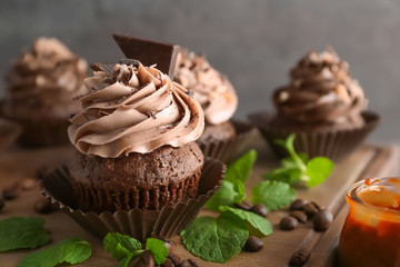 Tasty chocolate cupcake on wooden board