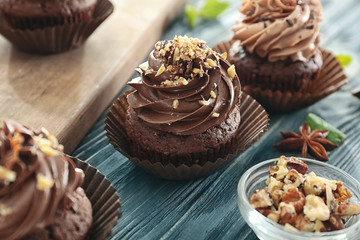 Tasty chocolate cupcakes on wooden table