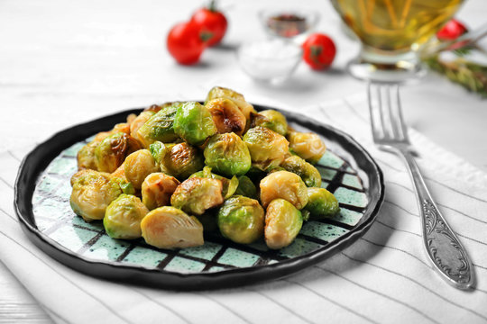 Plate with roasted Brussels sprouts on table, closeup