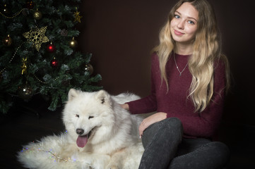 girl with big white fluffy dog sitting under the tree