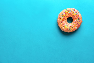 Obraz na płótnie Canvas Tasty glazed donut on color background