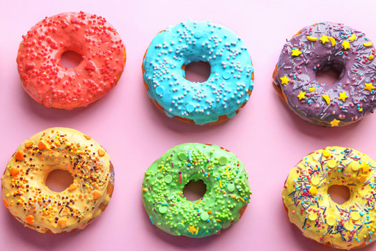 Tasty glazed donuts on color background
