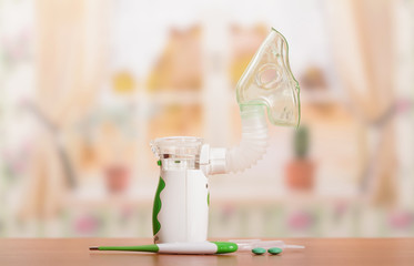 Ultrasonic nebulizer and an ampoule with the solution, thermometer and pills on table