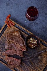 Sliced grilled steak and red wine on table