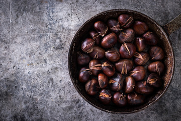 Roasted chestnuts on an old board. healthy food concept