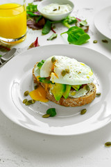 Sandwich, toast with avocado, soft cheese and poached egg on white background