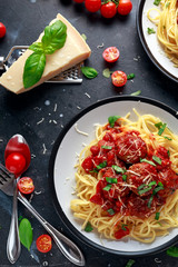 Spaghetti pasta meatballs with tomato sauce, basil, herbs parmesan cheese on dark background