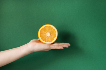 Tasty orange in a hand. holding a orange isolated on a colored background