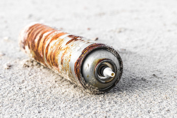 Verrostete Sprühdose am Strand