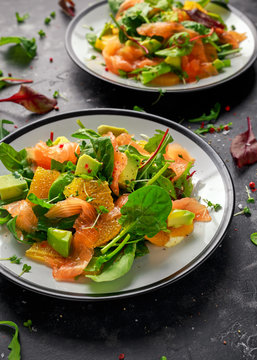 Fresh salmon salad with avocado, orange and green vegetables.