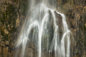 Fototapeta na wymiar silk water flows on the stones wall in croatia