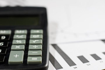 Obraz premium Calculations, calculations and economics on paper. Calculator and charts on a wooden table.
