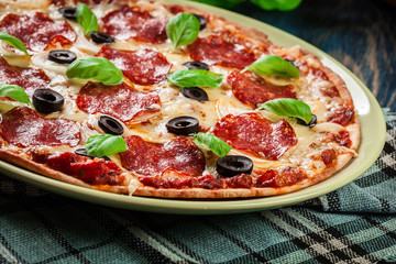 Pizza pepperoni with olives served