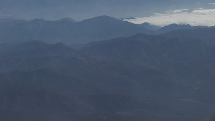 aerial shot from plane flying above the mountains in daytime