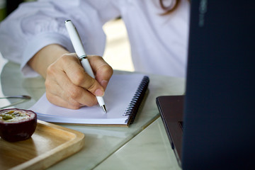 Woman writing working using laptop online