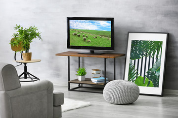 Modern TV set on stand in living room