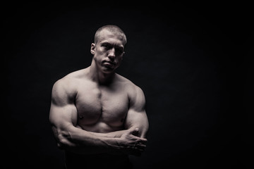 Fototapeta na wymiar portrait of a male bodybuilder on a black background isolated. monochrome. The concept of a photo of competing sports, health, fitness