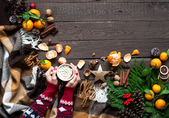 Hot Christmas drinks, coffee, cocoa or chocolate with marshmallows. Christmas composition on wooden background, branches, Christmas trees, Christmas decorations, tangerines.
