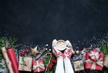 Fototapeta premium Christmas design Christmas . Christmas black background c fir tree, gift boxes, hot drinks, cocoa, coffee or hot chocolate with marmalade, Christmas decorations, Santa hat, star.