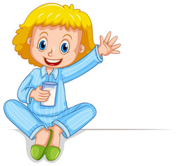 Little girl in pajamas holding glass of milk