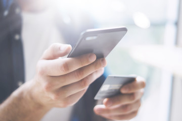 Hands with smartphone and credit card