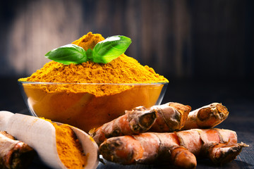 Composition with bowl of turmeric powder on wooden table © monticellllo
