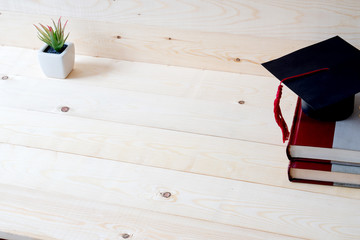 Graduation cap, hat on wood table graduation concept.