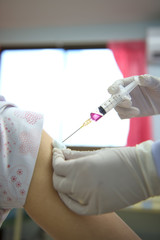 Soft focus nurses are vaccinations to patients using the syringe.Doctor vaccinating women in...