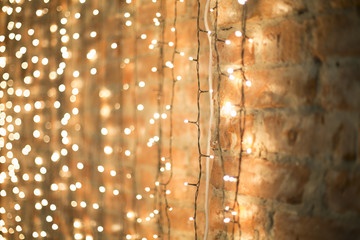 Christmas electric garland on white brick wall background