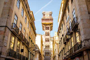Street view on the old buildings with famous saint Justa metal lift during the sunrise in Lisbon...