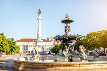 Fototapeta na wymiar Beautiful view on the fountain on the Rossio square with column during the sunny day in Lisbon city, Portugal