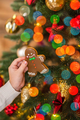 Christmas ginger man near a decorated Christmas tree and festive lights, Christmas card