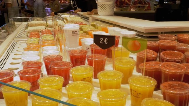 Freshly Squeezed Juice in Plastic Containers in the Shop Window. La Boqueria. Barcelona. Spain. Strawberry, kiwi, mango and other exotic fruits in plastic cups on the showcase at Mercat de Sant Josep.