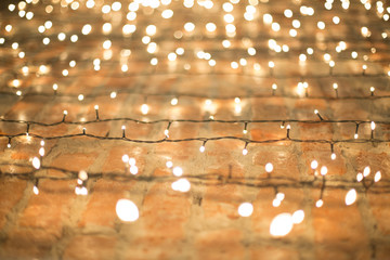 Christmas electric garland on white brick wall background