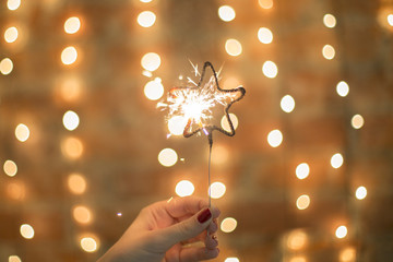 Night background with a star christmas sparkler. Sparkler Bokeh Colorful sparkler. Shallow focus