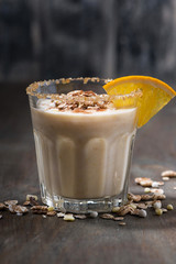 creamy cocktail with oats on dark table