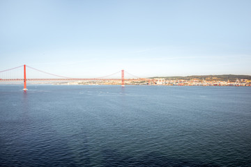 Wide angle view on the Tagus river and the famous 25th of April Bridge during the morning light in Lisbon city, Portugal