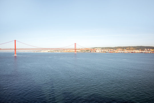 Wide angle view on the Tagus river and the famous 25th of April Bridge during the morning light in Lisbon city, Portugal