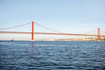 Fototapeta na wymiar Landscape view on the Tagus river and the famous 25th of April Bridge during the morning light in Lisbon city, Portugal