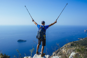 Hiker with blue daypack on an fantastic overview on the amalfi- coastline/ Positano, italy, europe