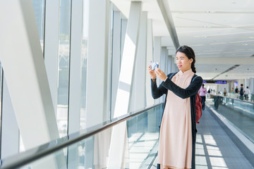 Girl taking picture while on the moving walkway