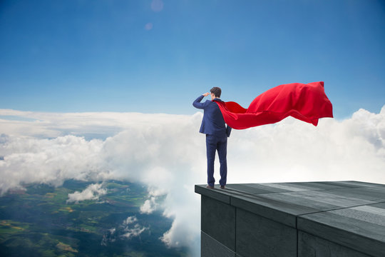 Super hero businessman  on top of building ready for challenge