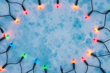 Christmas lights frame on blue background with copy space